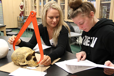 Two female students examing a skull in a lab