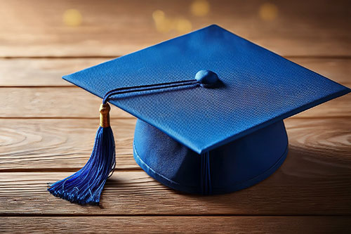 Blue graduation cap on wooden table