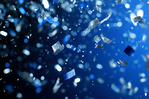 Silver and blue confetti falling on a blue background