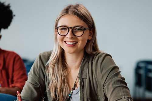 Smiling female college student attending class