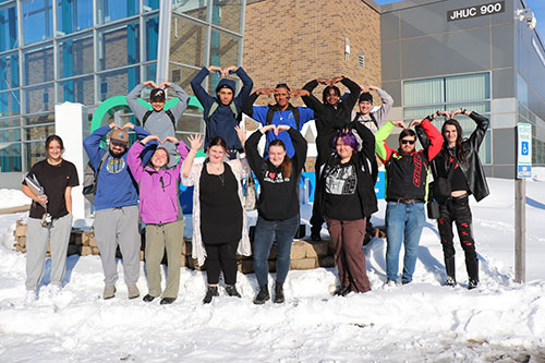Students standing around the "I Love Bay College" sign