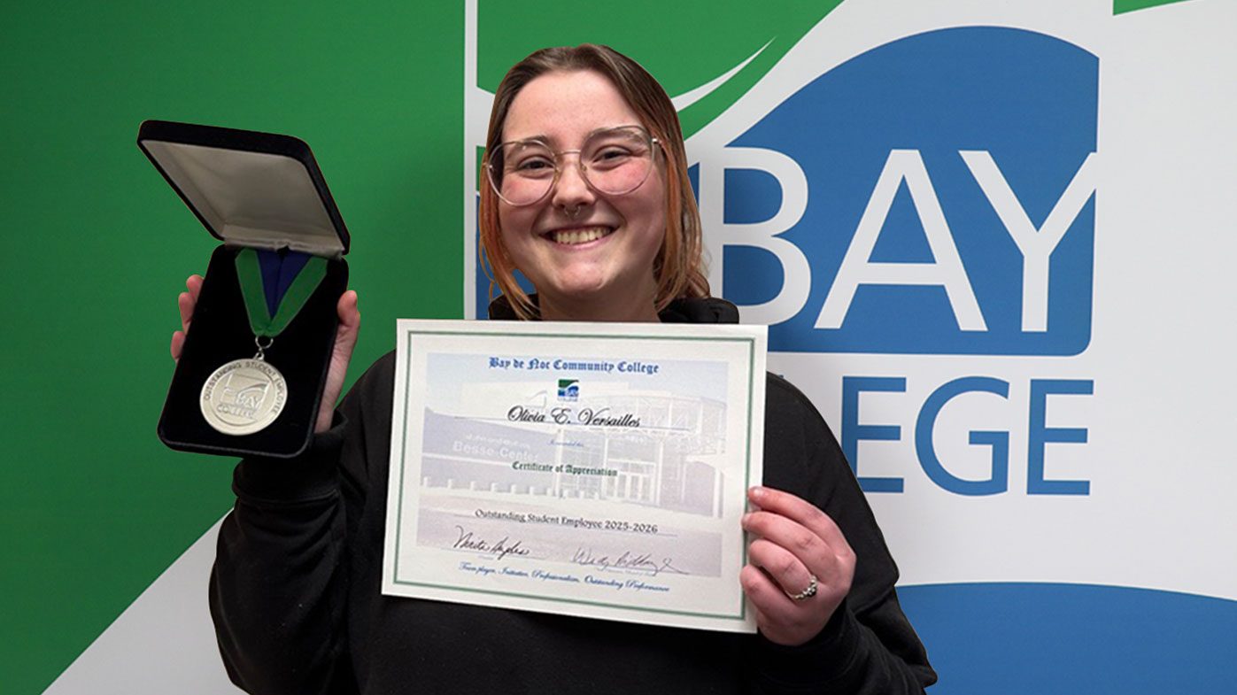 Bay College 2026 Outstanding Student Employee of the Year Olivia Versailles holding up her award medallion and certificate.